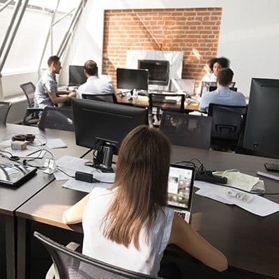 Mitarbeiter arbeiten in einem Großraumbüro mit ergonomischen Bürostühlen